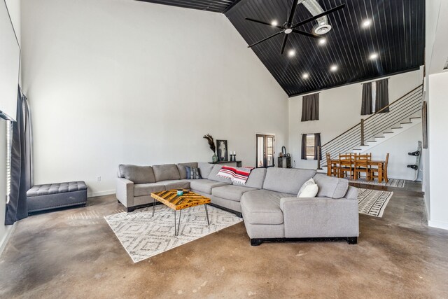 living room featuring ceiling fan, high vaulted ceiling, and concrete flooring