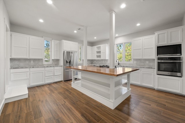 kitchen featuring sink, stainless steel appliances, wood counters, and white cabinets