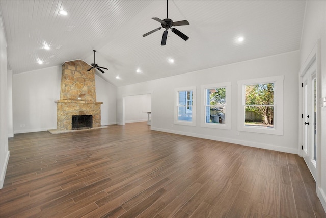 unfurnished living room with a stone fireplace, lofted ceiling, and dark hardwood / wood-style floors