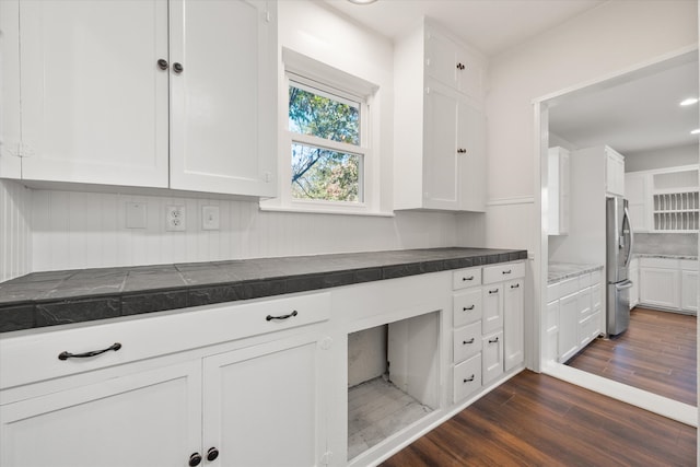 kitchen featuring stainless steel fridge, white cabinetry, and dark hardwood / wood-style floors