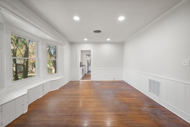 empty room with dark wood-type flooring and crown molding