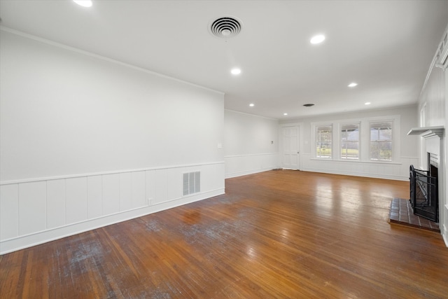 unfurnished living room featuring a fireplace, ornamental molding, and hardwood / wood-style flooring