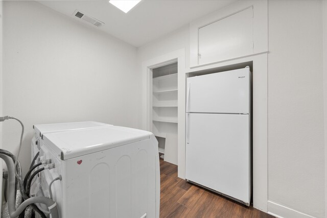 laundry area featuring washing machine and dryer and dark hardwood / wood-style flooring