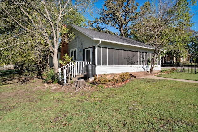 view of side of home with a lawn and a sunroom