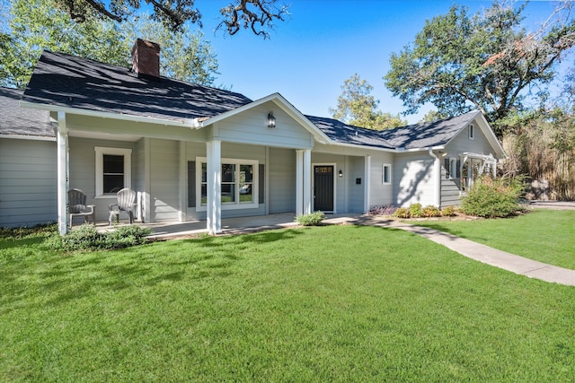 back of property featuring covered porch and a lawn