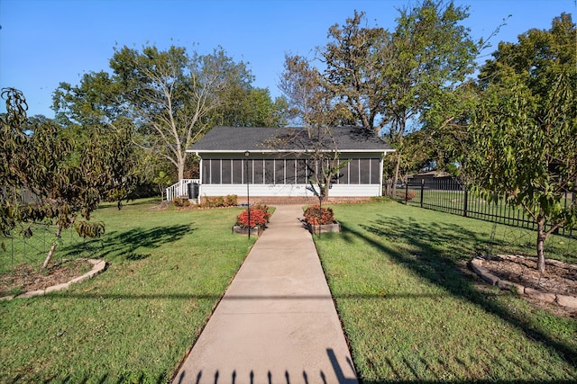 exterior space with a front lawn and a sunroom