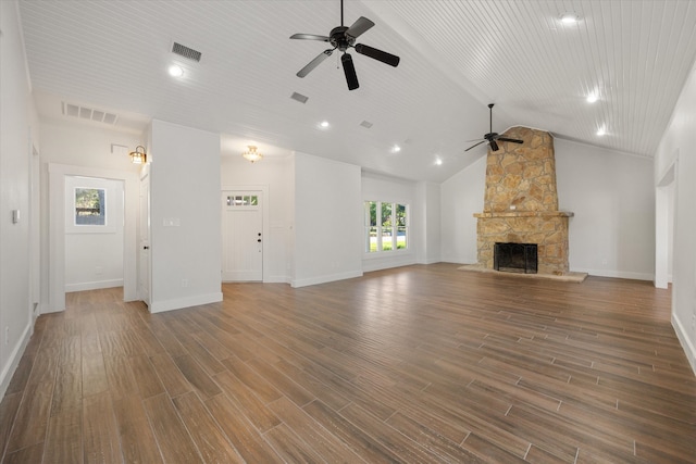 unfurnished living room with lofted ceiling, ceiling fan, and a stone fireplace