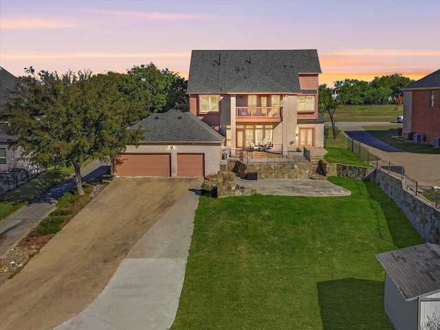 view of front of home featuring a balcony, a garage, and a lawn