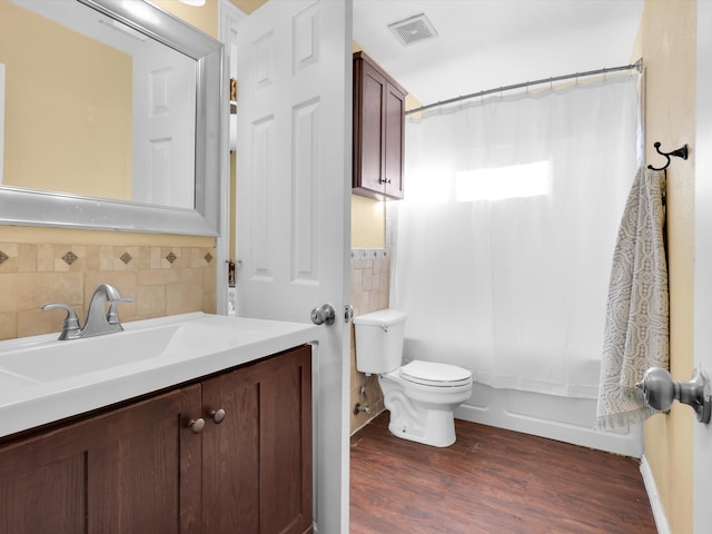 full bathroom featuring vanity, decorative backsplash, toilet, shower / bathtub combination with curtain, and wood-type flooring