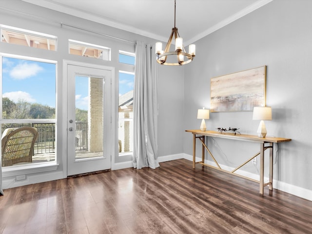 doorway to outside featuring crown molding, dark hardwood / wood-style flooring, and a notable chandelier