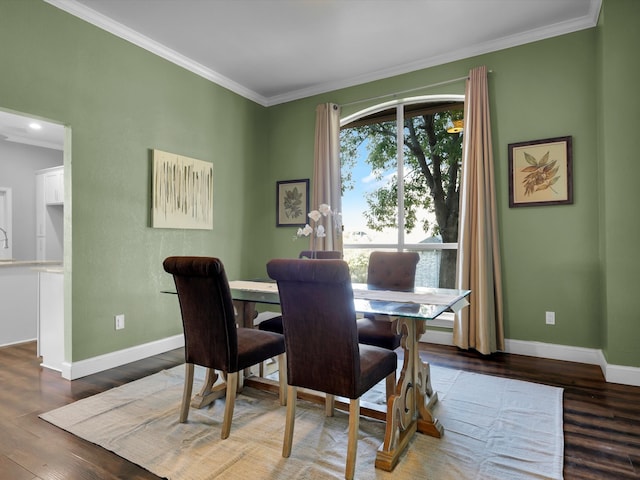 dining space featuring dark hardwood / wood-style flooring and crown molding