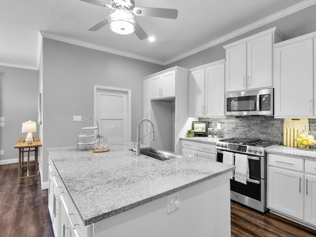 kitchen with white cabinets, sink, an island with sink, light stone counters, and stainless steel appliances