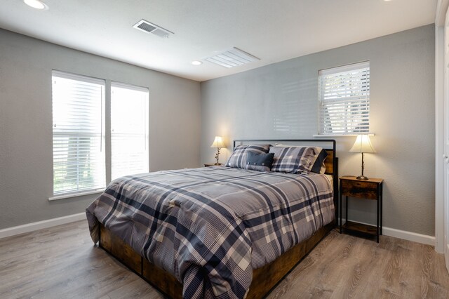 bedroom with light wood-type flooring and multiple windows