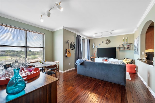 living room with dark hardwood / wood-style floors, crown molding, and rail lighting