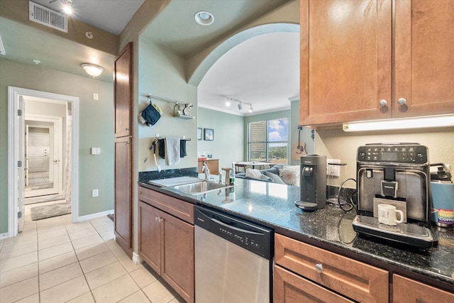 kitchen featuring rail lighting, sink, light tile patterned floors, dark stone countertops, and dishwasher