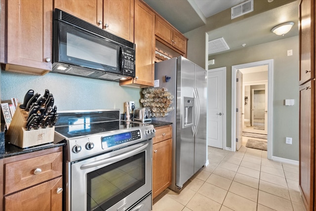 kitchen featuring light tile patterned floors and stainless steel appliances