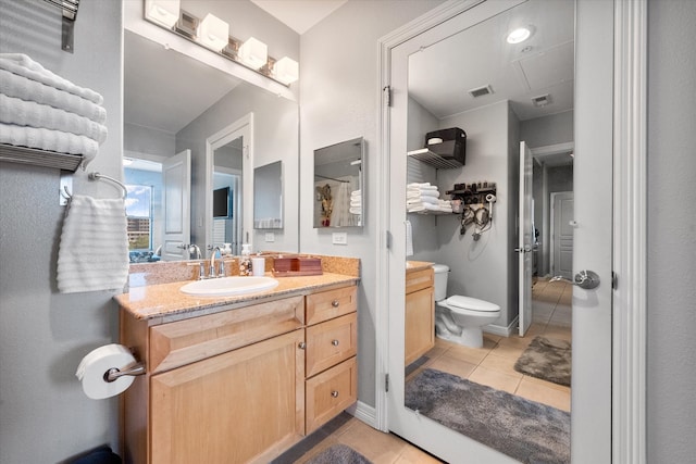 bathroom featuring tile patterned floors, vanity, and toilet