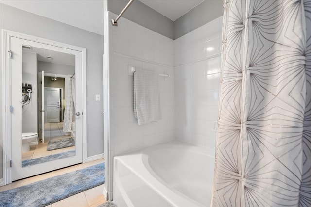 bathroom featuring tile patterned flooring,  shower combination, and toilet