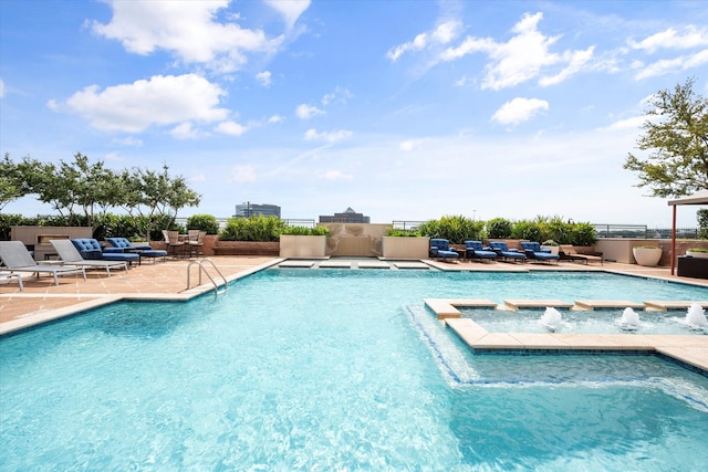 view of swimming pool with pool water feature and a patio