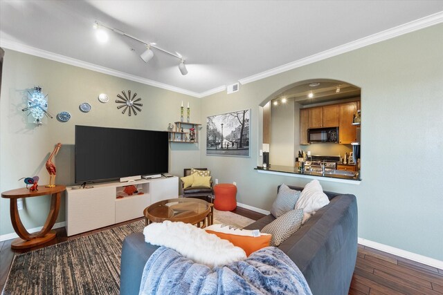 living room featuring rail lighting, dark hardwood / wood-style floors, and crown molding