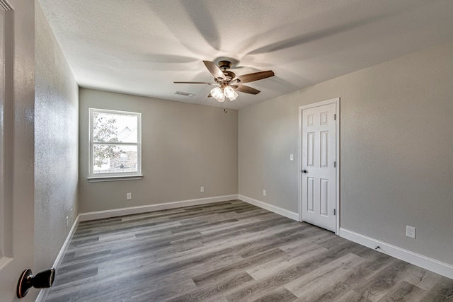 unfurnished room featuring ceiling fan, a textured ceiling, and light hardwood / wood-style flooring