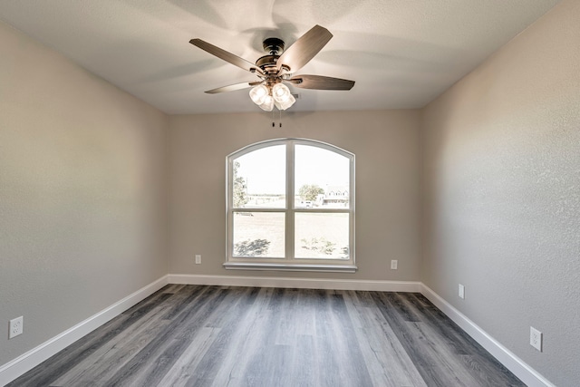 empty room with ceiling fan and dark wood-type flooring