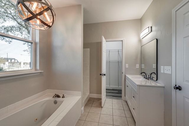 bathroom with tile patterned flooring, vanity, and tiled bath