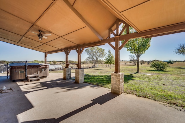 view of patio featuring ceiling fan, a rural view, and a hot tub