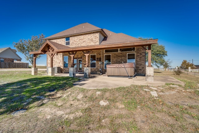 rear view of house featuring central AC unit, a patio area, a yard, and a hot tub