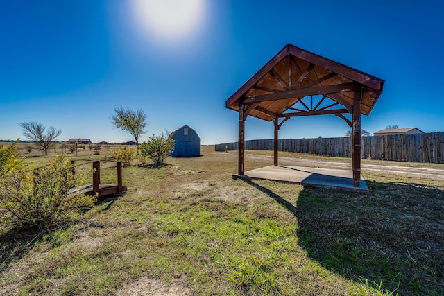 view of yard featuring a gazebo, a rural view, and an outdoor structure