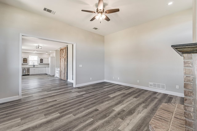 unfurnished living room featuring ceiling fan, dark wood-type flooring, and sink