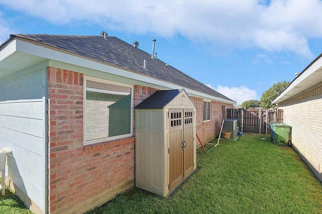 view of outbuilding with central AC and a yard