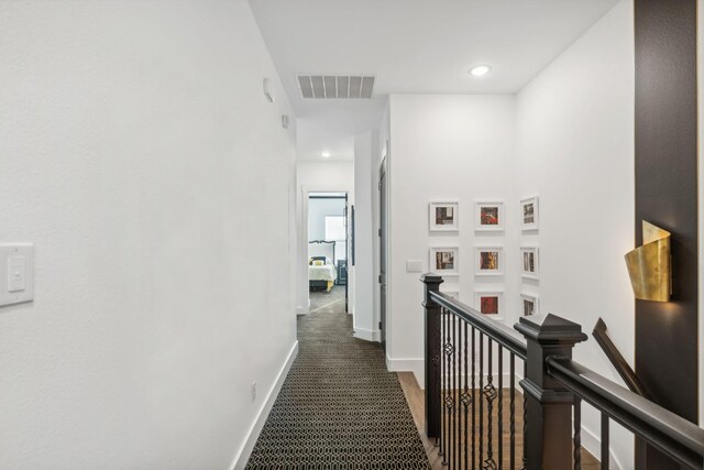 hallway featuring dark carpet