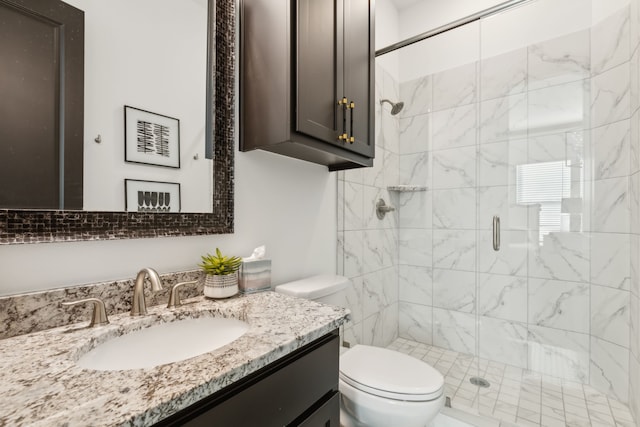 bathroom with vanity, toilet, and a shower with door