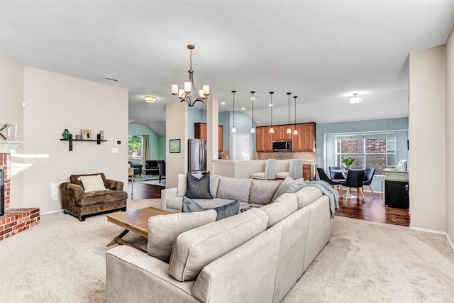 carpeted living room with an inviting chandelier and a brick fireplace