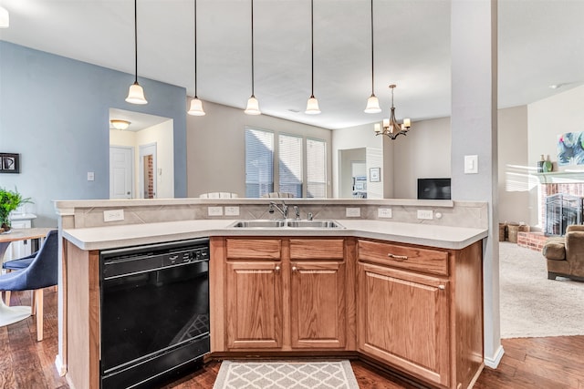 kitchen featuring a fireplace, sink, pendant lighting, dishwasher, and dark hardwood / wood-style floors