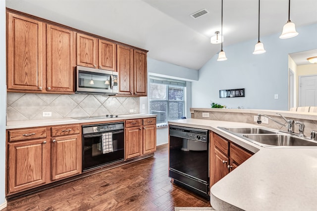 kitchen with vaulted ceiling, sink, black appliances, pendant lighting, and dark hardwood / wood-style floors