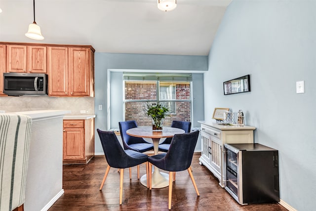 kitchen featuring dark wood-type flooring, backsplash, decorative light fixtures, fridge, and lofted ceiling