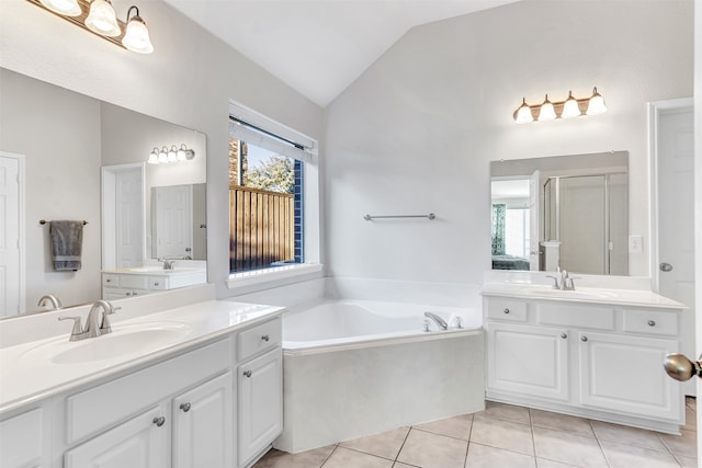 bathroom with tile patterned floors, independent shower and bath, a wealth of natural light, and vaulted ceiling