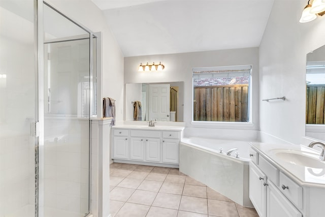 bathroom with tile patterned flooring, vanity, vaulted ceiling, and shower with separate bathtub