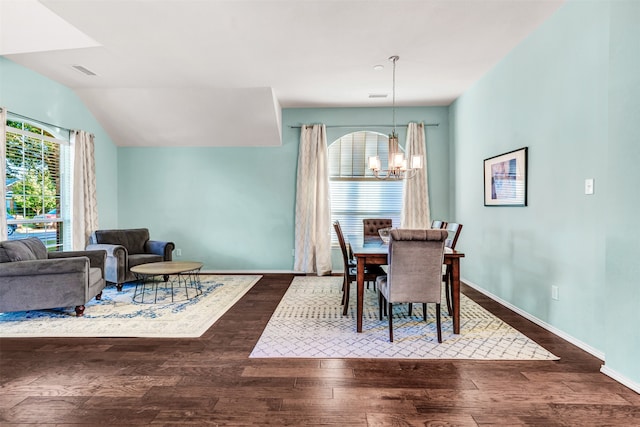 dining space with vaulted ceiling, dark hardwood / wood-style flooring, and an inviting chandelier