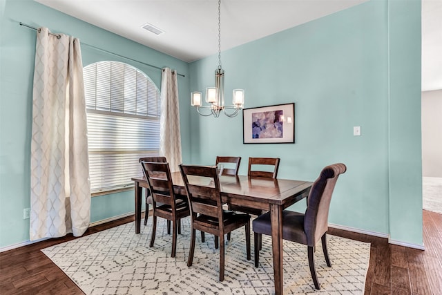 dining area featuring a notable chandelier and dark hardwood / wood-style flooring