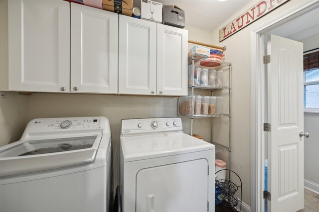 clothes washing area with cabinets and washer and clothes dryer