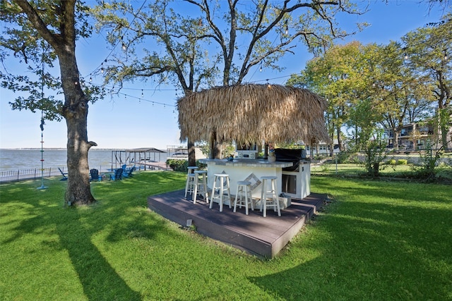 view of yard with a deck with water view and a bar