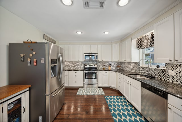 kitchen featuring backsplash, dark hardwood / wood-style flooring, stainless steel appliances, sink, and white cabinetry