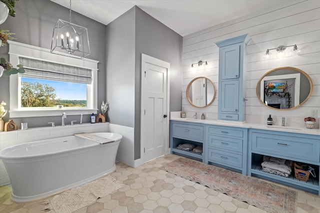 bathroom featuring vanity, a notable chandelier, tile patterned flooring, a bathing tub, and wood walls