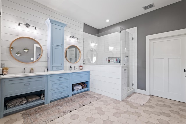 bathroom featuring vanity, a shower with door, and wood walls