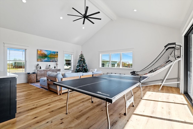 rec room with ceiling fan, a wealth of natural light, high vaulted ceiling, and light wood-type flooring