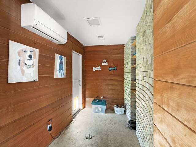 hallway with an AC wall unit and wooden walls