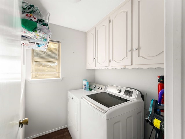 clothes washing area with washing machine and dryer, cabinets, and dark wood-type flooring